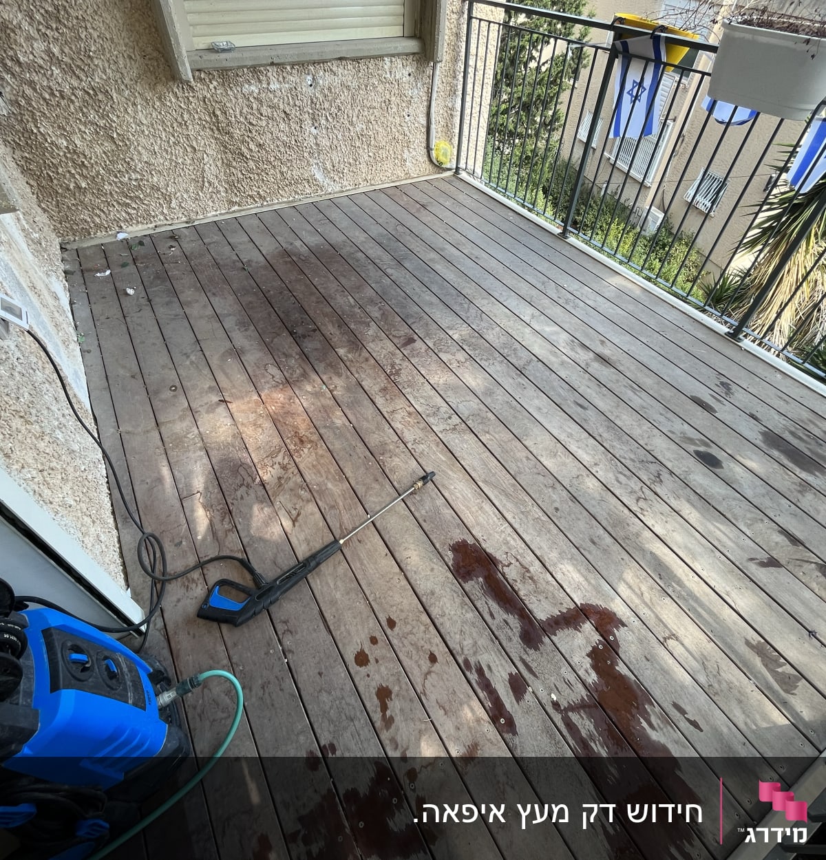 מכונת שטיפה בלחץ על רצפת עץ במרפסת